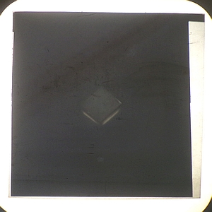 Calcite crystal between crossed polarizers, optical axis aligned with the bottom polarizer